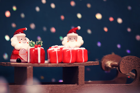 selective photography of two Santa Claus figurines in table thumbnail