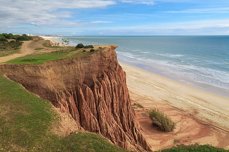 hill in front of sea during daytime thumbnail