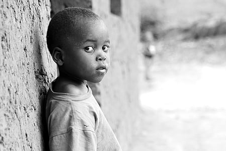 boy in t-shirt leaning against concrete wall thumbnail