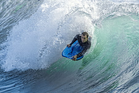 man surfing on sea waves at daytime thumbnail