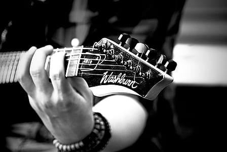 person playing guitar in grayscale photography thumbnail