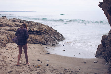 woman standing on seashore during daytime thumbnail