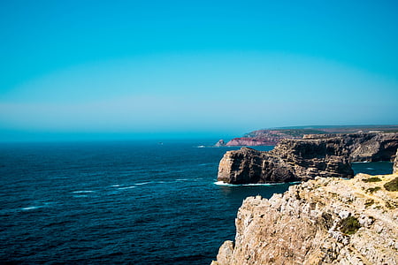 body of water beside rock formations thumbnail