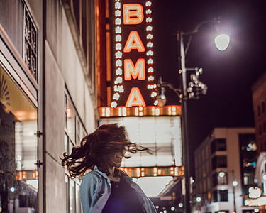 woman with building signage and light post background thumbnail