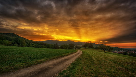 green grass under the cloudy sky during daytime thumbnail