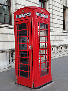 red telephone booth beside concrete building thumbnail