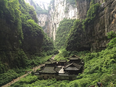 black house below mountain cliffs thumbnail
