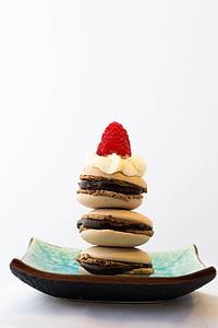 pile of three beige French macarons topped with raspberry thumbnail