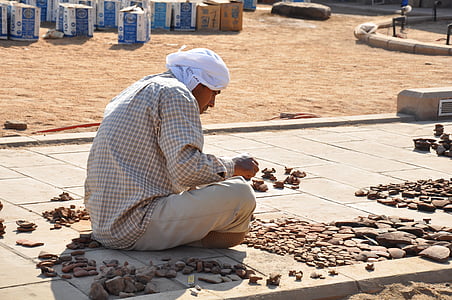 man sitting on concrete pathway near cardboard boxes thumbnail
