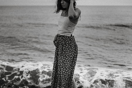 grayscale photography of woman standing near body of water thumbnail