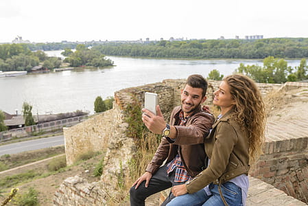 Woman And Man Sitting Against Body Of Water thumbnail