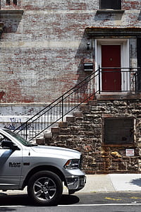 silver Dodge RAM 1500 pickup truck parking near gray brick building thumbnail