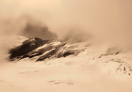 snow cap mountain under gray clouds during snowy days thumbnail