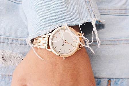 person wearing gold-colored analog watch thumbnail