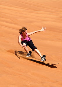 woman in pink tank top and black pants sand skiing thumbnail