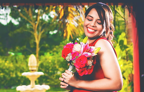 woman smiling and holding flowers thumbnail