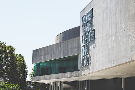gray concrete building by the trees thumbnail