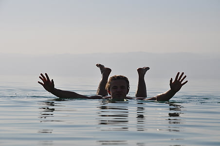 man swimming on body of water thumbnail