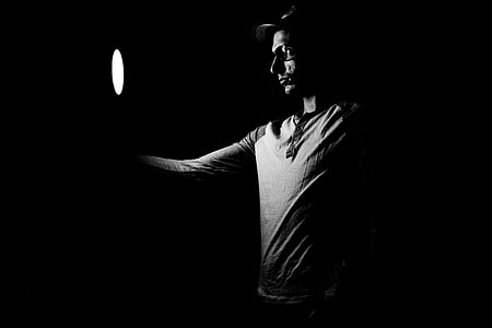 man holding round light inside dark room thumbnail