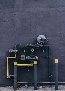 yellow and black water pipe near concrete wall thumbnail