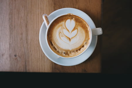 cappuccino in white ceramic teacup on brown table thumbnail