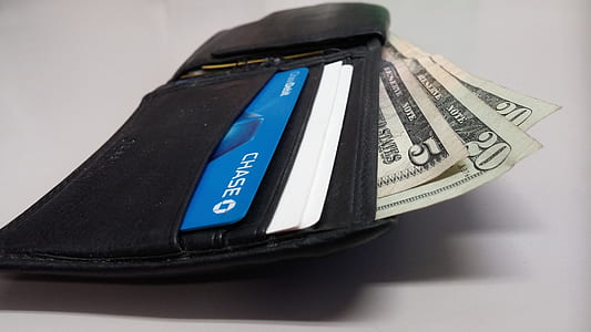 US dollar banknote on black leather bifold wallet thumbnail