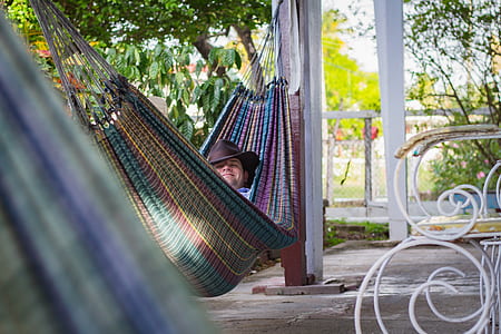 person lying on multicolored hammock thumbnail