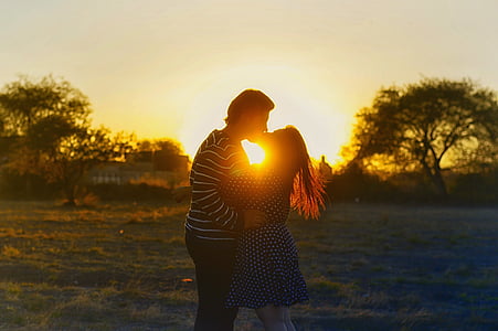 man and woman kissing near trees thumbnail