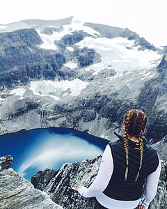 Woman Wearing Blue Vest Standing On Cliff thumbnail