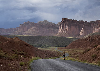 man running in road near mountain at daytime thumbnail