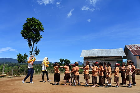 group of boys and girls standing near tree thumbnail