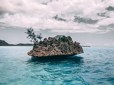 brown rock in middle of sea during daytime thumbnail