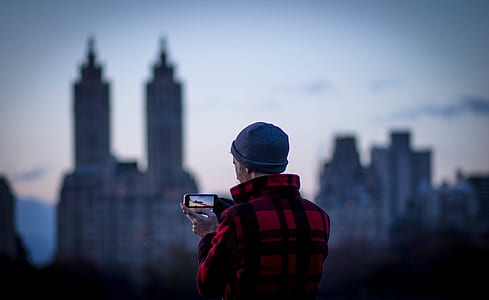 man holding camcorder showing tower building thumbnail
