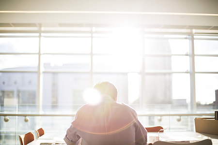 person in front of a sunlight and brown wooden table thumbnail