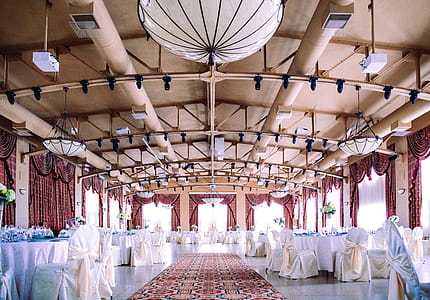 An elegant wedding hall with well arranged tables and chairs thumbnail