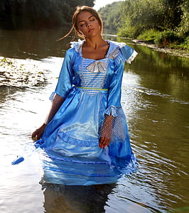 woman wearing blue satin dress on body of water thumbnail