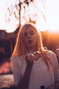 shallow focus photography of woman blowing bubbles thumbnail