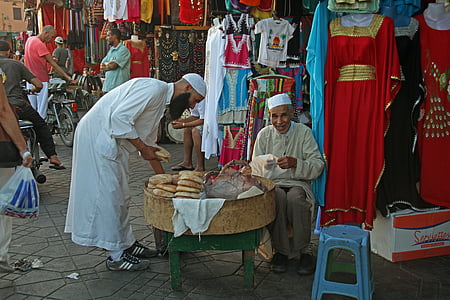 man sitting on chair beside clothes display thumbnail