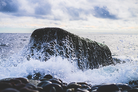 black stone formation on body of water thumbnail