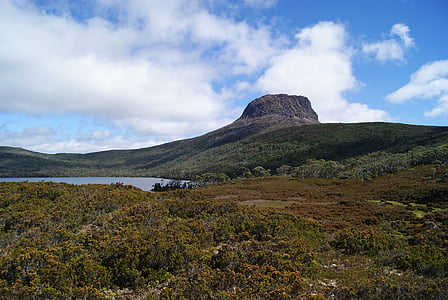 mountain beside body of water during daytime thumbnail