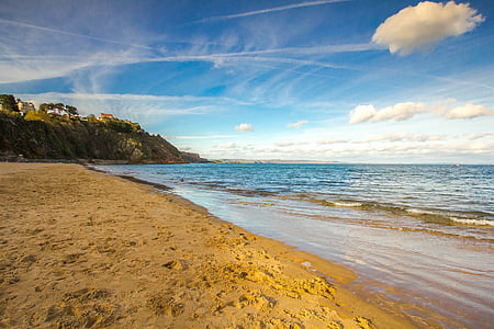 footprints by the beach under blue and white sky during daytime thumbnail
