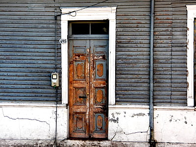 gray and white building with brown wooden panel door thumbnail