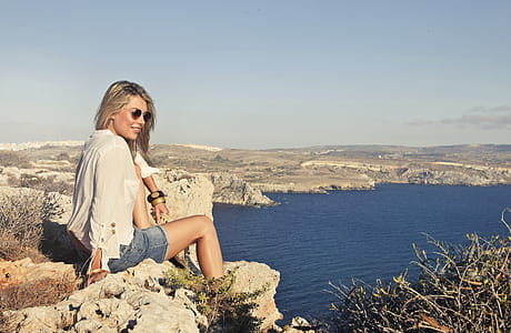 Photo of a Woman Sitting on the Cliff thumbnail