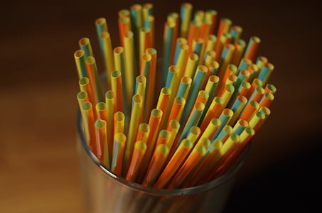 assorted-color straws in clear glass rack thumbnail