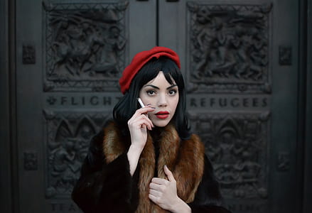 shallow focus photograph of woman holding cigarette thumbnail