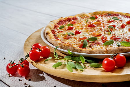 pizza with green leaves on brown wooden plate thumbnail