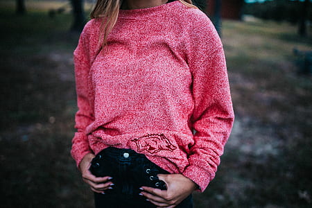woman wearing red long-sleeved shirt standing near trees during daytime thumbnail