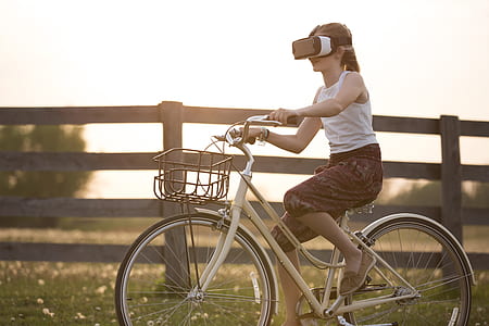 Girl Wearing Vr Box Driving Bicycle during Golden Hour thumbnail