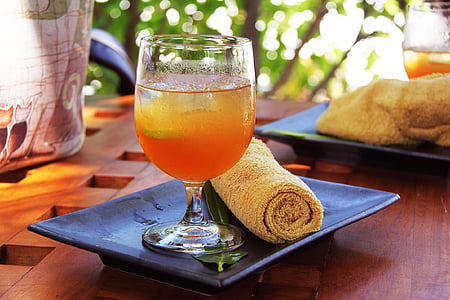 selective focus photography of short stemmed drinking glass filled with orange juice thumbnail