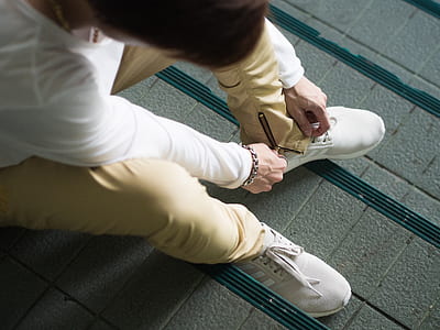 man sitting while fixing shoe lace thumbnail